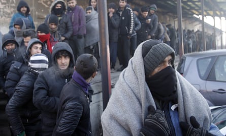 Migrants queue for food in front of an abandoned warehouse in Belgrade.