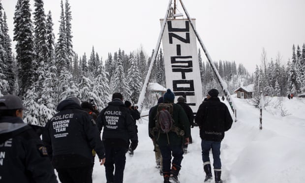 RCMP officers join hereditary chiefs and supporters as they walk towards the Unist’ot’en anti-pipeline camp on 9 January 2019.