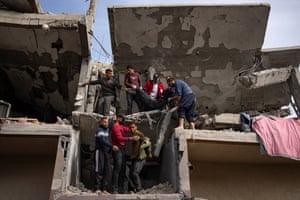 Rafah, Gaza Strip. Palestinians carry the body of a woman found under the rubble of a destroyed building after an Israeli airstrike