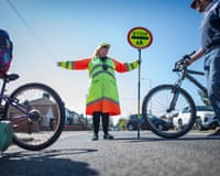 School crossing patrol officer Lynne Gorrara, equipped with body cam, stopping traffic and helping pedestrians across Foxhall Road in Ipswich