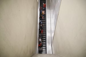 Commuters ride down an escalator