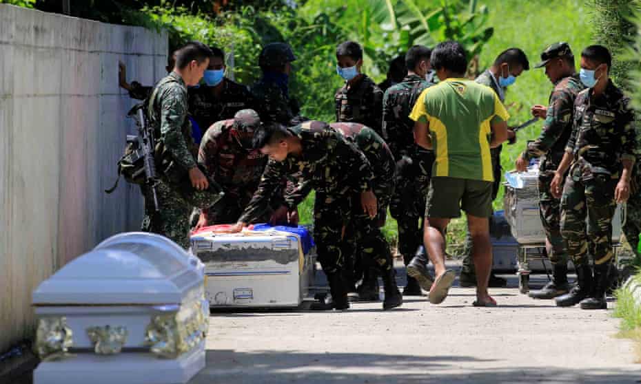 Philippine troops place a flag on a case containing the body of a comrade killed during an assault against insurgents in Marawi.