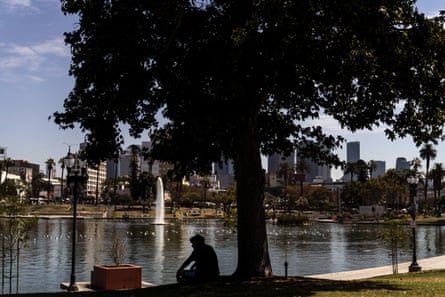 A man rests in the shade under a tree in Los Angeles during a record-breaking September heatwave.
