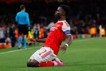 Bukayo Saka slides on the turf after scoring