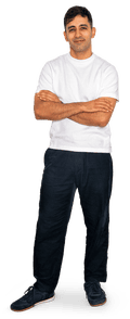 A smiling man with dark hair in a white T-shirt, dark trousers and trainers.
