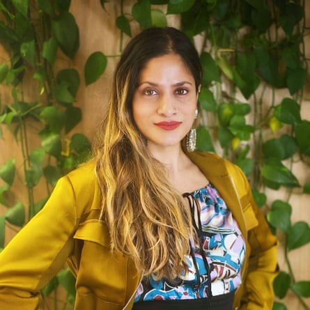 A woman poses in front of vines