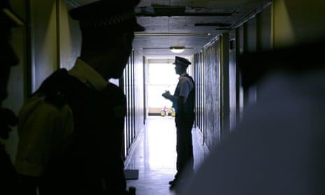 two male police officers in a dark corridor