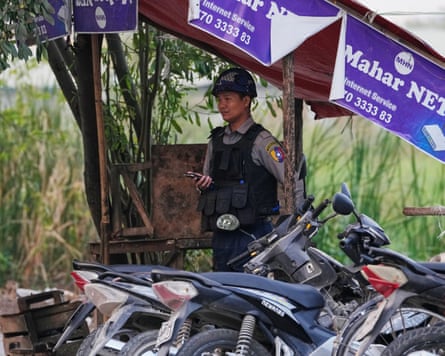 A police officer standing guard in front of a polling station