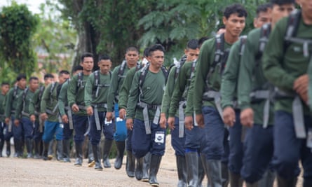 New members of EVU, the Indigenous patrol group that Pereira helped to create, march through Atalaia do Norte on their way to a training course in the jungle.