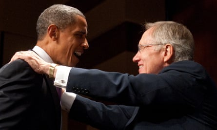 Obama and Reid facing each other, both smiling. Reid has placed both his hands on Obama's shoulders