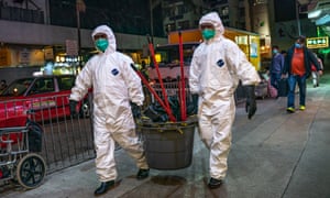 Workers from Department of Health carry cleaning supplies into a residential building in Hong Kong.