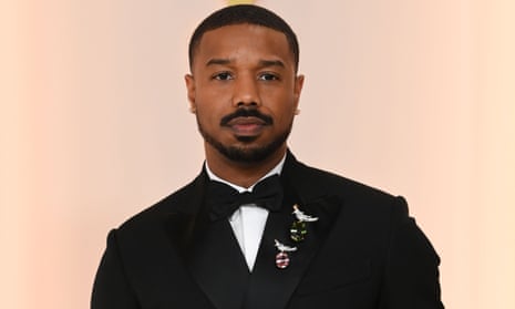 Michael B Jordan in a bowtie and tuxedo with two diamond-encrusted Tiffany brooches pinned to his lapel