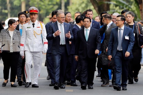 Vietnamese Prime Minister Pham Minh Chinh (C-R) and his Australian counterpart Anthony Albanese (C-L) converse as they walk at the Presidential Palace in Hanoi.