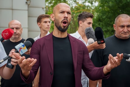 Andrew Tate gestures while speaking to the media after a hearing in Bucharest, Romania