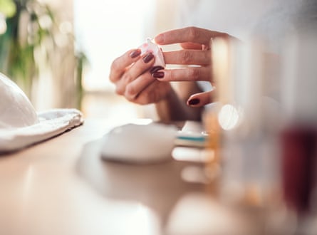 A woman using a cotton pad to remove polish