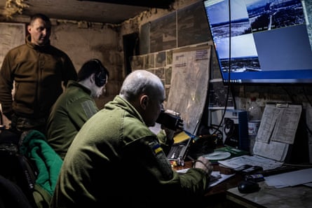 Viacheslav looks over servicemen monitoring radio feed and live cameras in Ukraine’s 68th brigade’s underground command base. (Maps have been blurred to remove detail for security reasons).