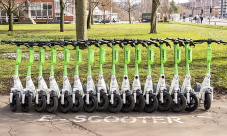 A row of Lime e-scooters in a special bike parking bay.