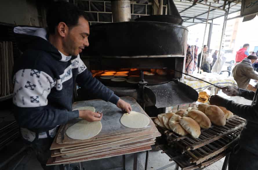 An Egyptian baker arranges bread at a bakery at Arish city