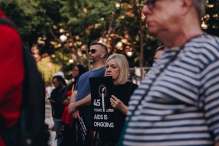 A person holds a sign that reads ‘45 years later Aids is ongoing’