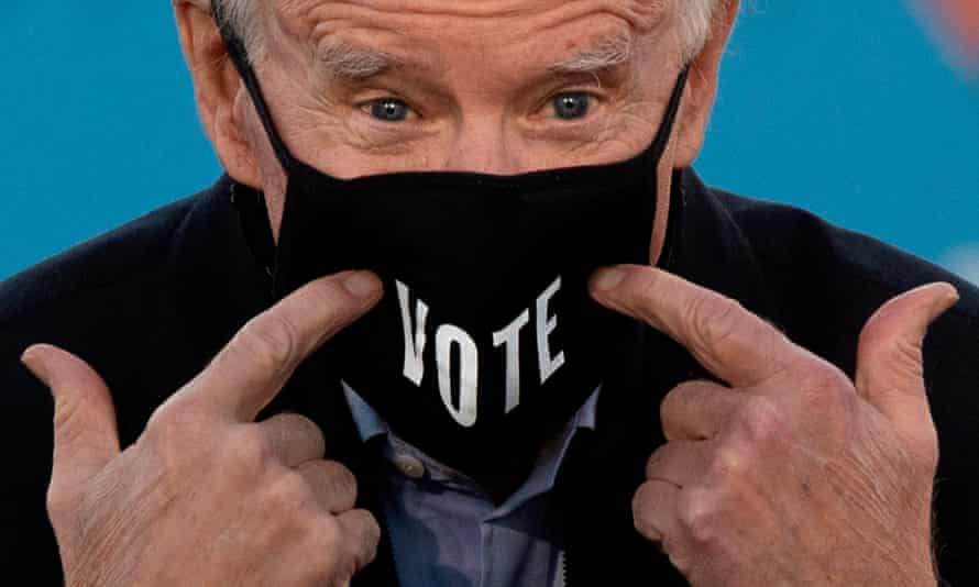 Joe Biden points to his face mask in Atlanta, Georgia in January.