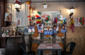 Prints of Maradona’s Napoli era (with teammates Bruno Giordano and Careca in the central picture) displayed alongside symbols of the Neapolitan culture as Pulcinella, a pizza maker, Totò and the Kingdom of the Two Sicilies’ coat of arms at an open air restaurant in the Quartieri Spagnoli.