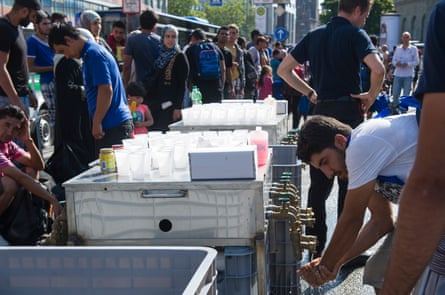 Refugees drink from water taps outside Munich central station