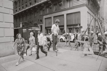 A child bounces on a pogo stick on a busy street