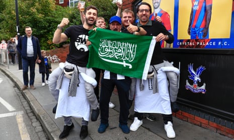 Newcastle fans outside Selhurst Park celebrating the takeover with a Saudi Arabian flag