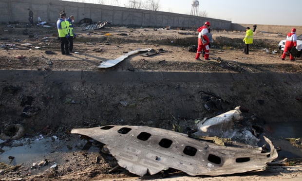 Emergency services personnel walk amidst the wreckage after an Ukraine International Airlines Boeing 737-800 crashed.