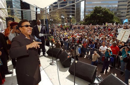 Woman standing before large crowd speaking