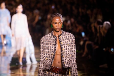 A model on the runway wearing a Chanel suit jacket with nothing underneath.