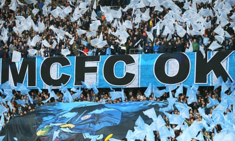 Manchester City fans wave flags at the Etihad Stadium