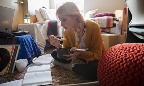 Female college student eating and studying on floor in dorm roomJGTH13 Female college student eating and studying on floor in dorm room posed by model
