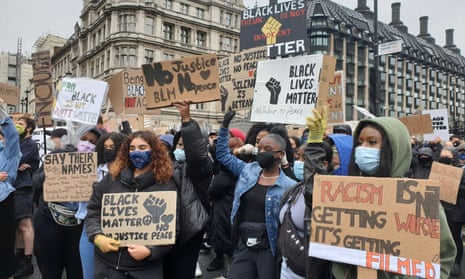 Demonstrators hold signs during a Black Lives Matter protest in Parliament Square, London