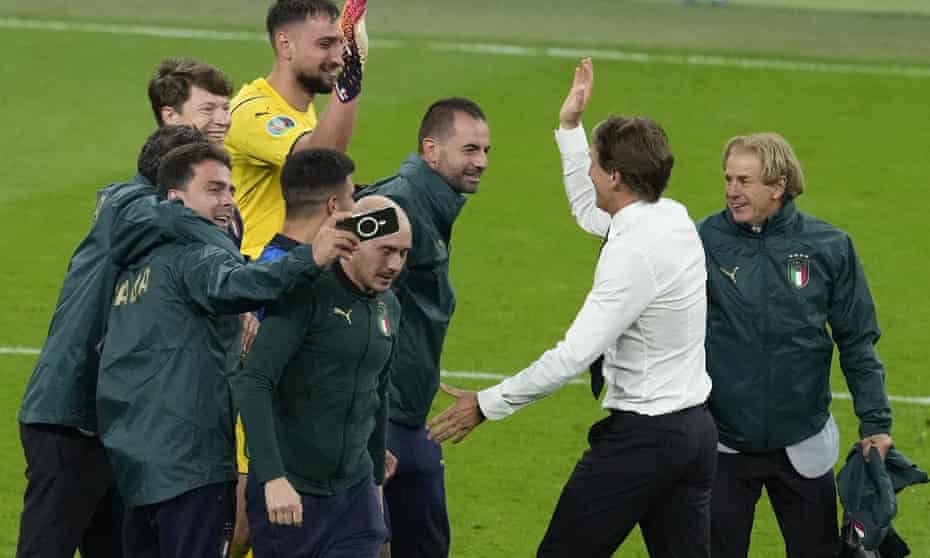 Italian coach Roberto Mancini (second from right) congratulates his goalkeeper Gianluigi Donnarumma after beating Spain on penalties.