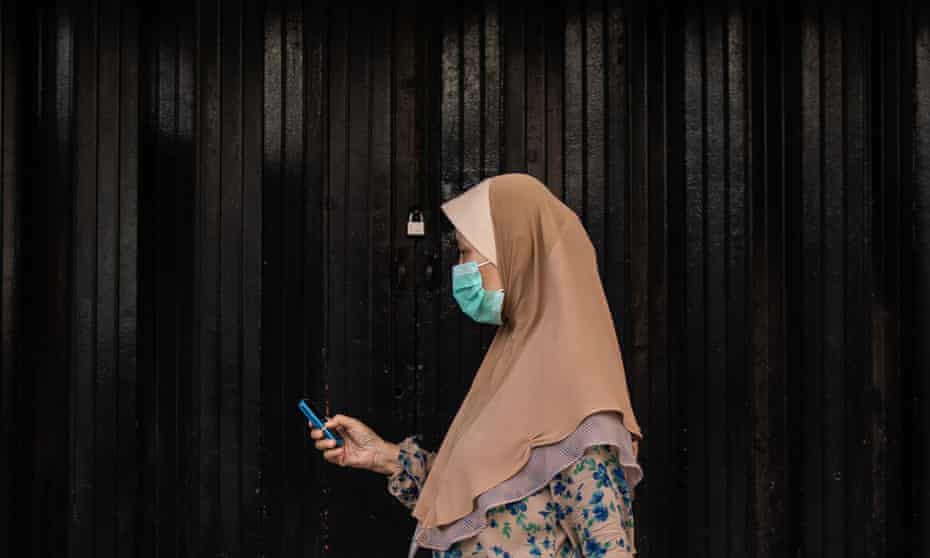 A woman walks past a closed shop in Kuala Lumpur, Malaysia, during the nationwide coronavirus lockdown.