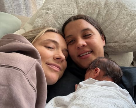 Sam Kerr and Kristie Mewis lying with their baby on Kerr