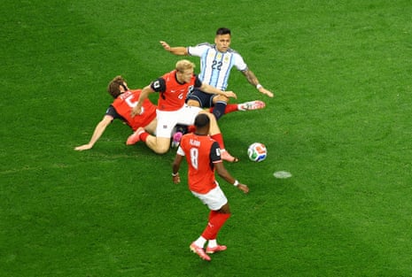 Argentina's Lautaro Martinez is fouled by Austria's Xaver Schlager and Stefan Posch resulting in a penalty.