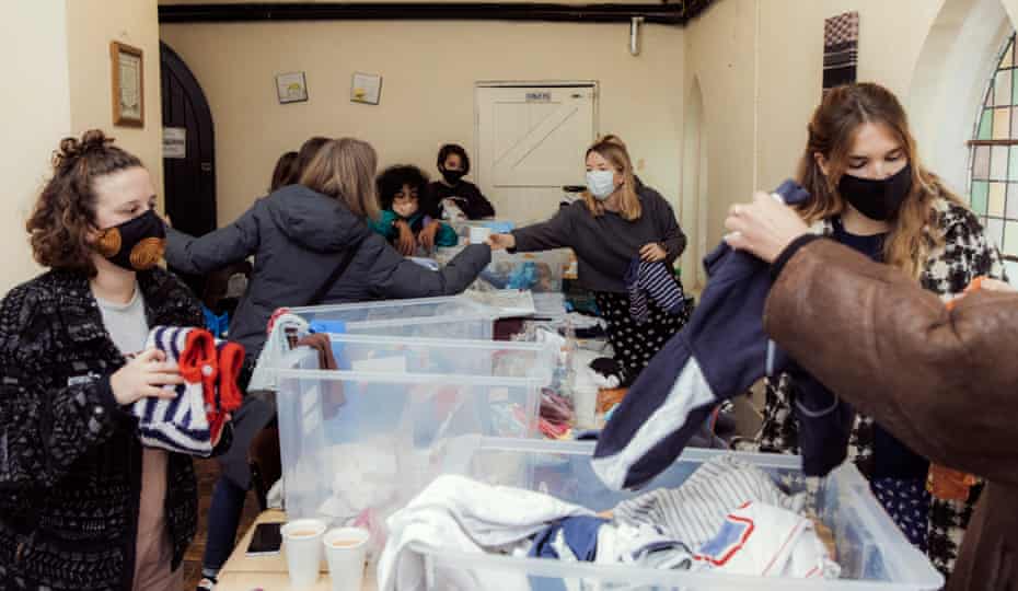 Volunteers from Clapton CFC, a local women’s football club, go through clothes donated to the E5 Baby Bank in Hackney, sorting them into zip-locked bags labelled by age groups, 8th November, 2020.