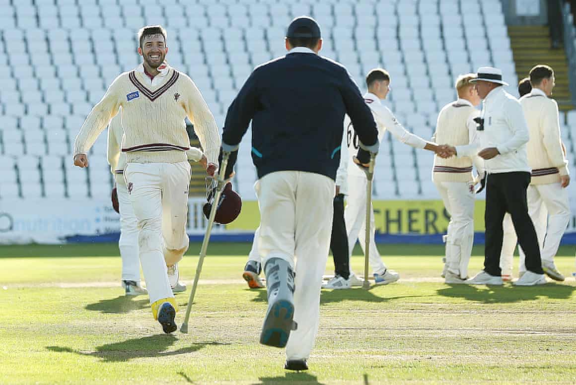 Tom Banton (with crutches) runs over to celebrate with Craig Overton after their win against Surrey.