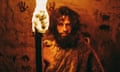 Portrait of a primeval caveman wearing an animal skin in a cave, holding a lit torch
