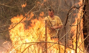 Ian Wheeler fights a fire on his neighbour's property in Killabakh, NSW, 13 November 2019.