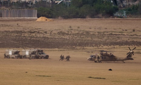 Israeli soldiers carry a stretcher toward a helicopter near the border with Gaza Strip, as seen from southern Israel.