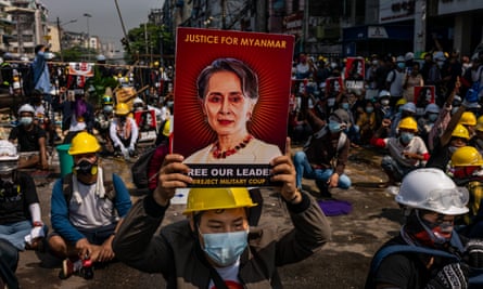 An anti-coup protester holds up a placard bearing an image of Aung San Suu Kyi in Yangon