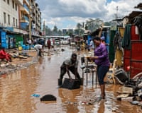 People try to recover belongings on a flooded street in Nairobi.