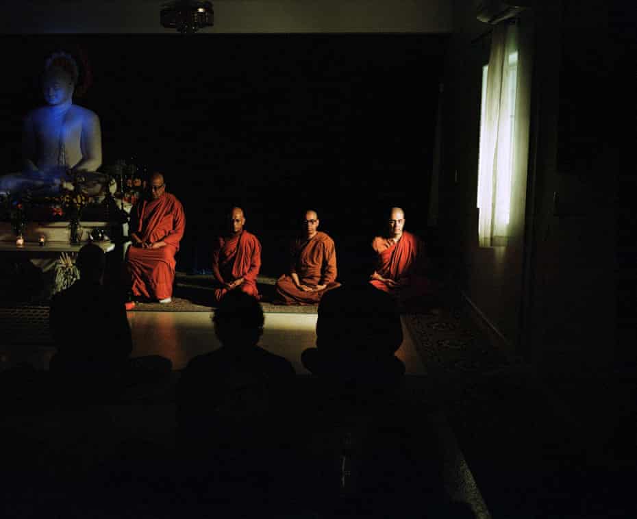 Four monks in red hoods meditate