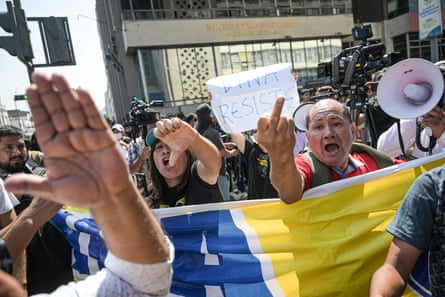 Supporters of President Dina Boluarte gesture at opponents protesting outside the Peruvian prosecutor’s building in Lima