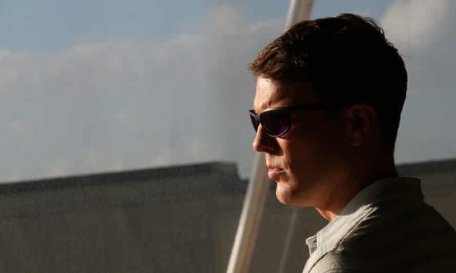 Jake Lacy as Shane, in sunglasses, looking cruel