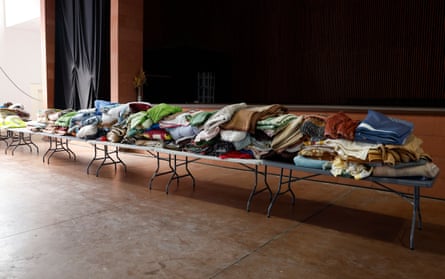 Blankets piled up on a row of trestle tables