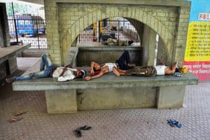 People rest in the shade under a bridge in Allahabad, India